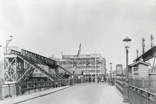 169356 Gezicht op de spoorwegovergang en de voetgangersbrug richting het Mariniersplein te Amsterdam, ter hoogte van de ...